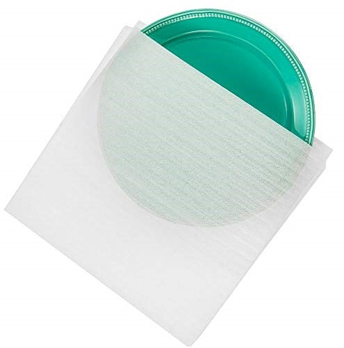 Pack of twelve 12x12 inch white polyethylene foam pouches containing a green dinner plate inside.